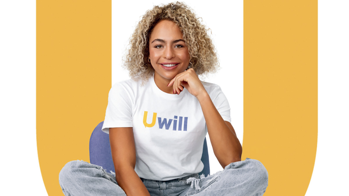 Student using Uwill online therapy, sitting and smiling at camera. 