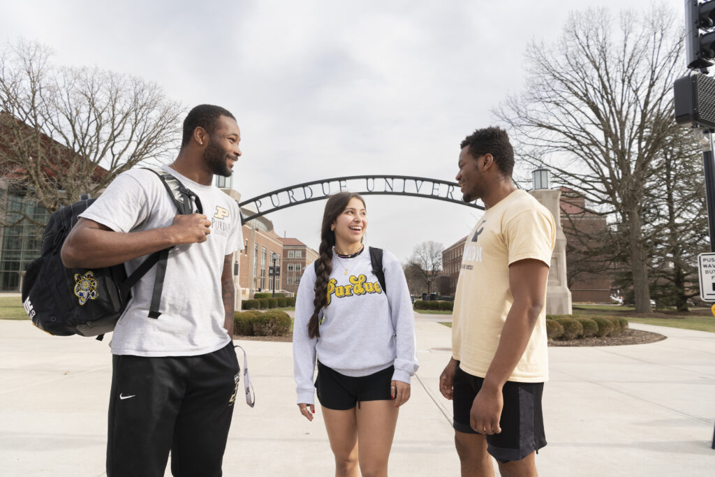 3 students talking on campus