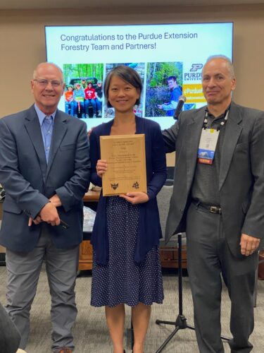 Zhao Ma accepts the 2024 Family Forests Education Award on behalf of Lenny Farlee and the other project team members.