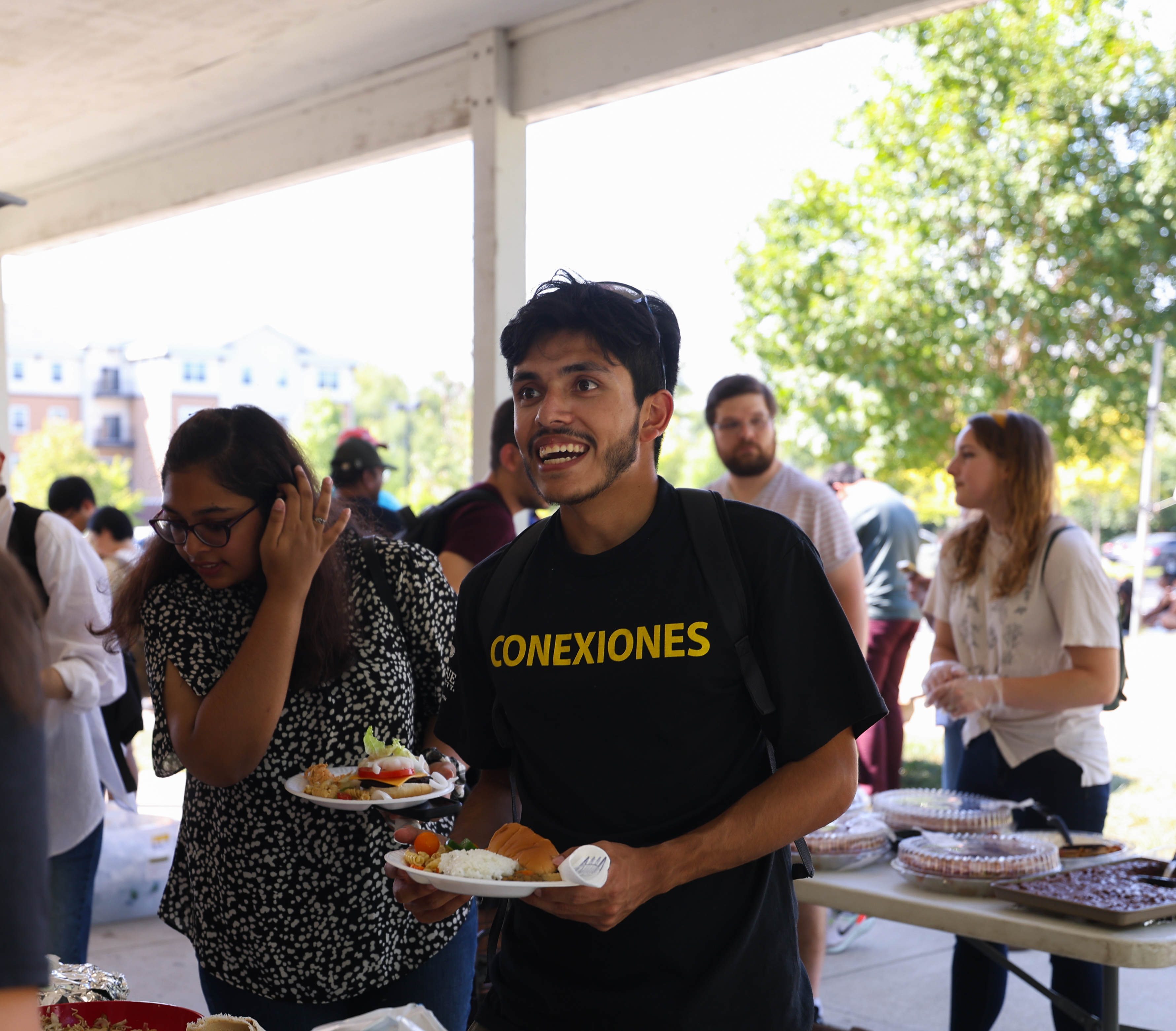 Students and hosts enjoying food at a cookout.