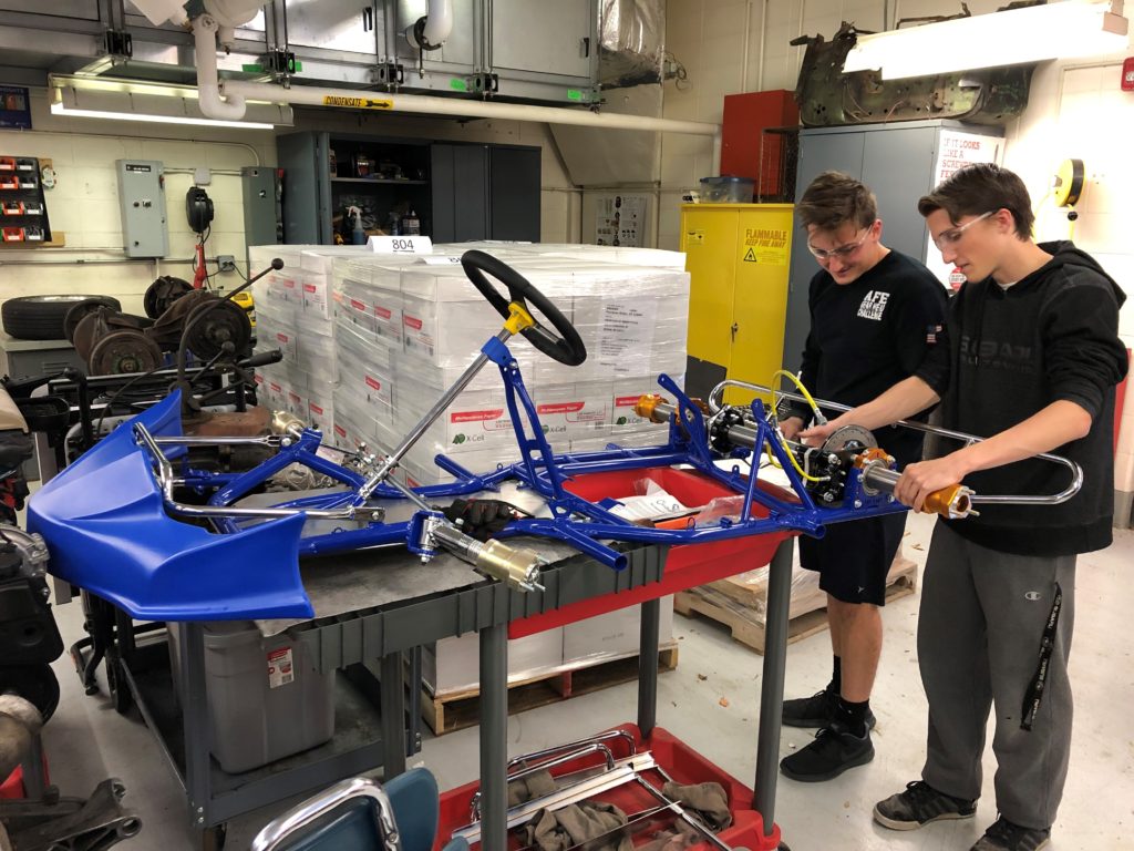 Students with a metal go kart frame