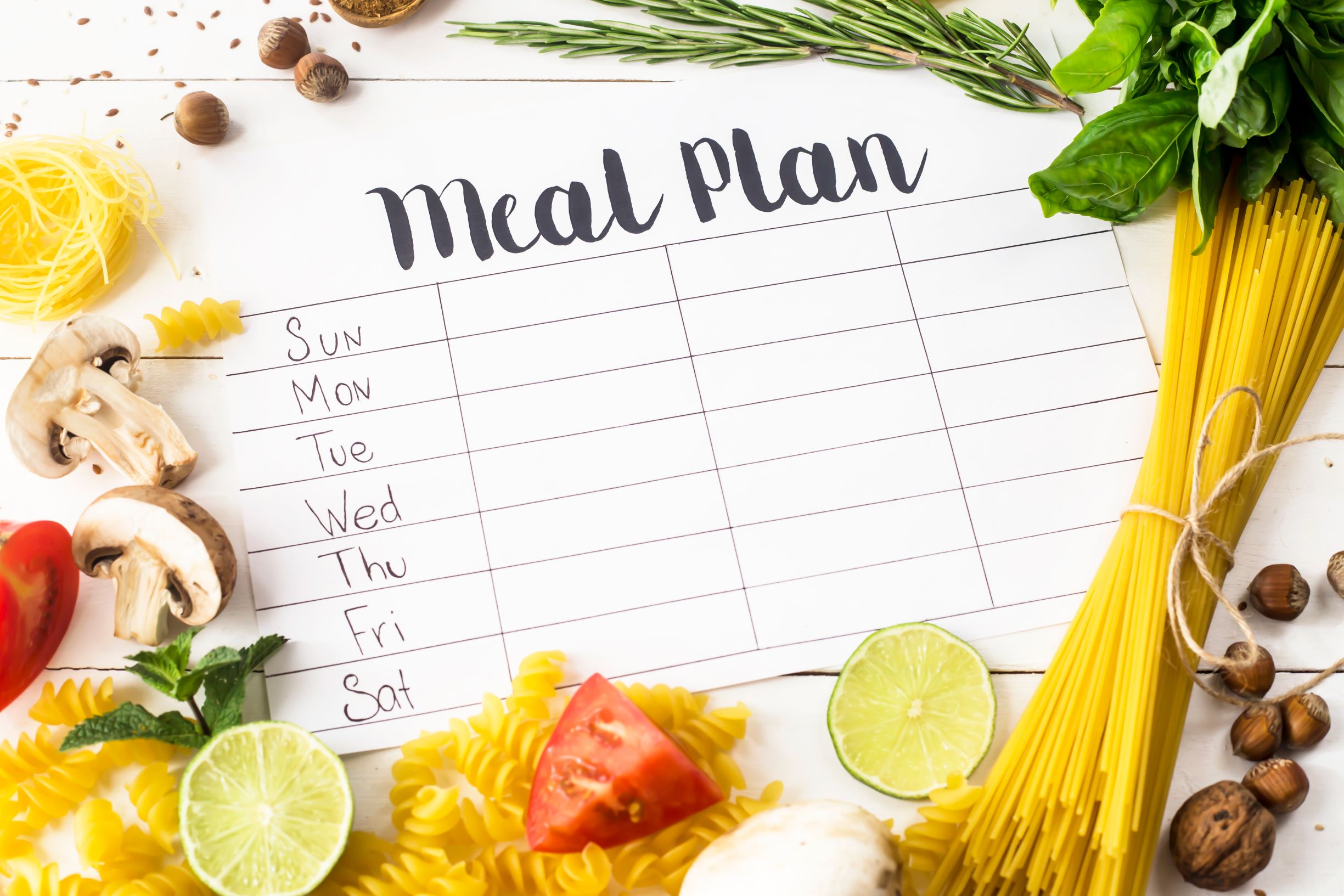 Meal plan weekly calendar with veggies surrounding it.