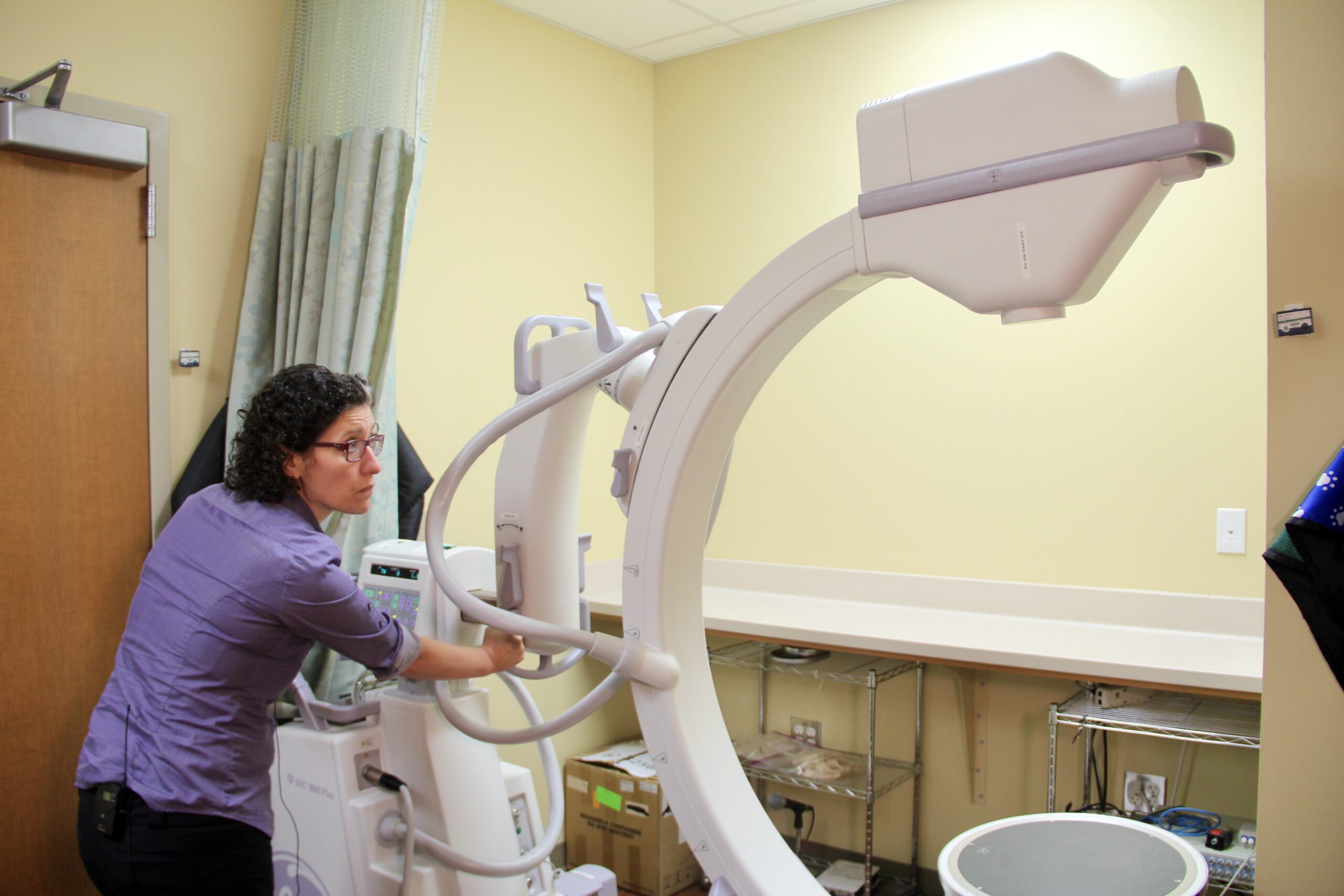 Georgia Malandraki adjusts a C-arm videofluoroscopy unit.