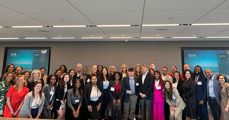 A large group of people pose for a photo in a conference room