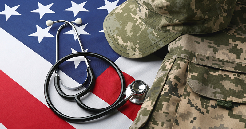 A military uniform and stethoscope sit on top of an American flag.