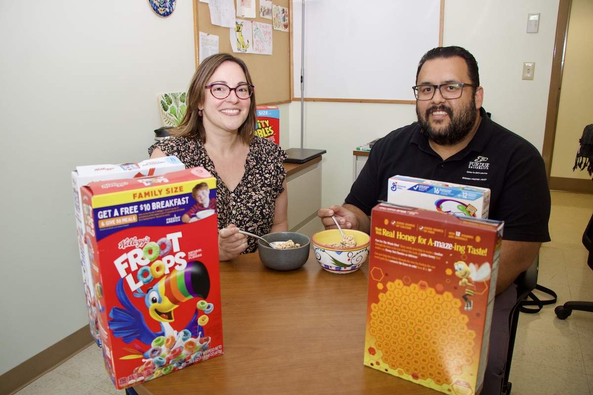 Sarah Eason and Salvador Vazquez sit at a table to have cereal.