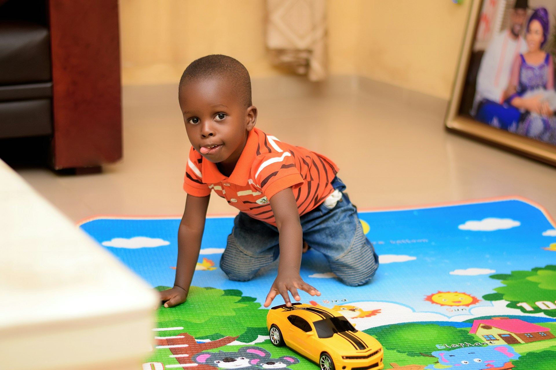 Young boy playing with a car on the floor