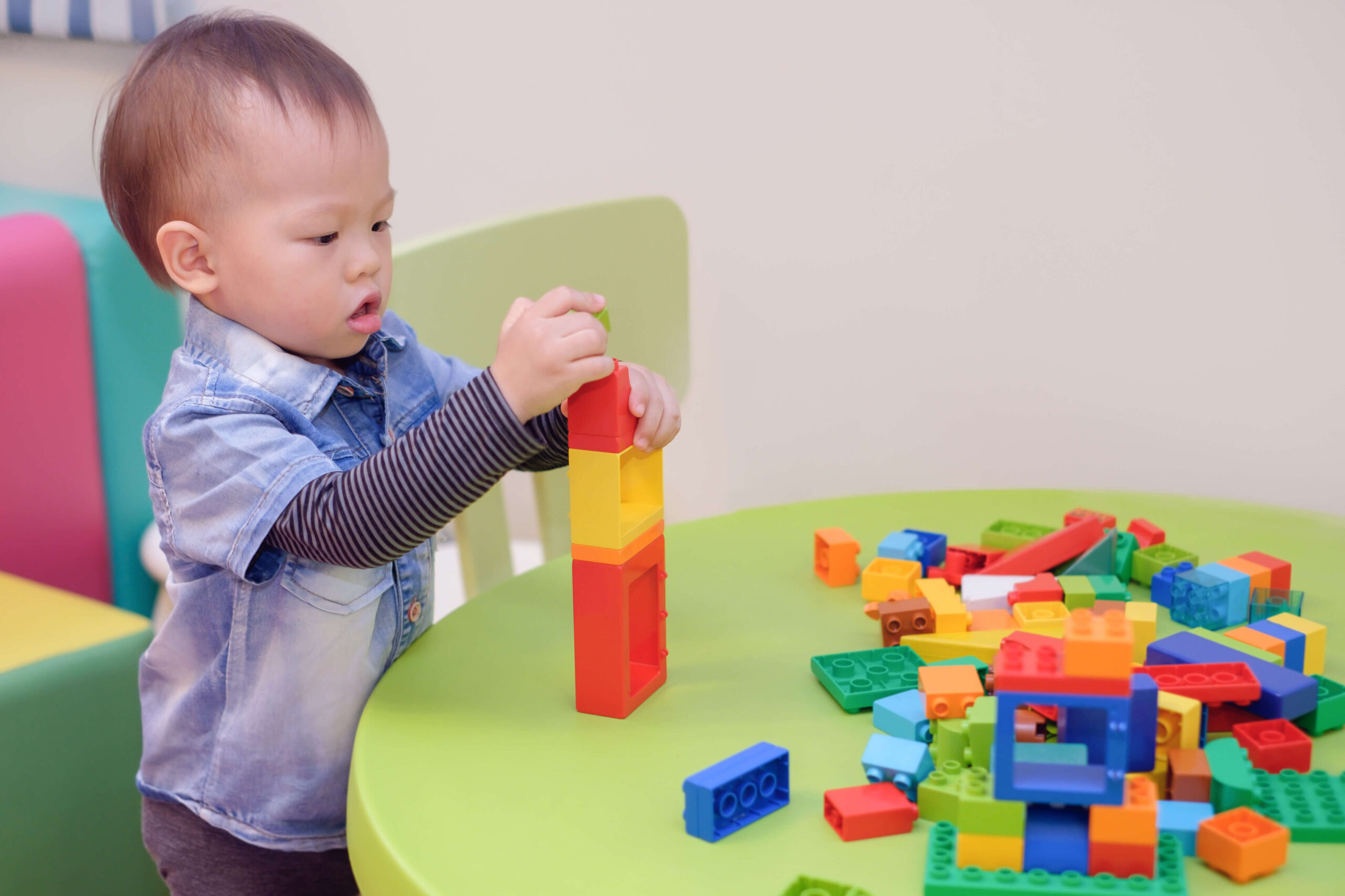 toddler boy building with lego blocks