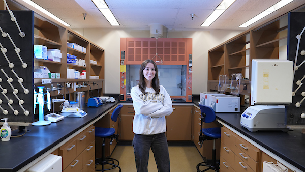 Young woman standing in a research lab.