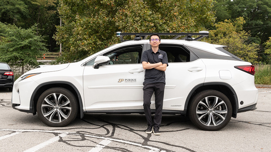 Purdue University assistant professor Ziran Wang stands next to a test autonomous vehicle that he and his students equipped to interpret commands from passengers using ChatGPT or other large language models. (Purdue University photo/John Underwood)