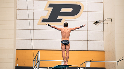 A diver from Purdue Men’s Swimming and Diving on a diving board.