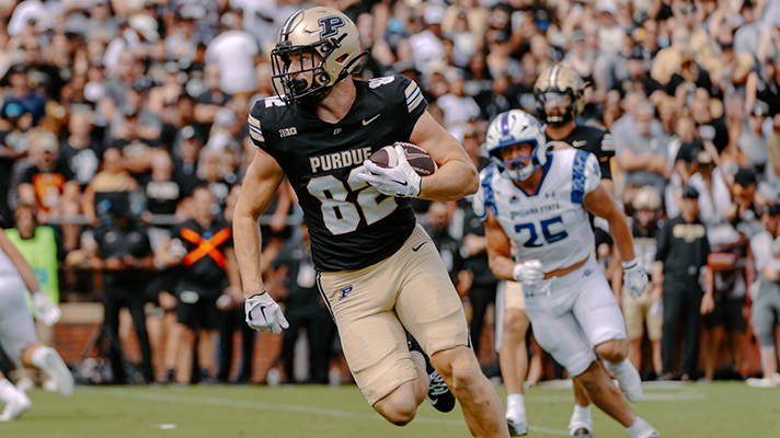 Purdue Boilermaker football’s Drew Biber running with a football.