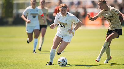 Purdue Women’s Soccer’s Kayla Budish running with a soccer ball.