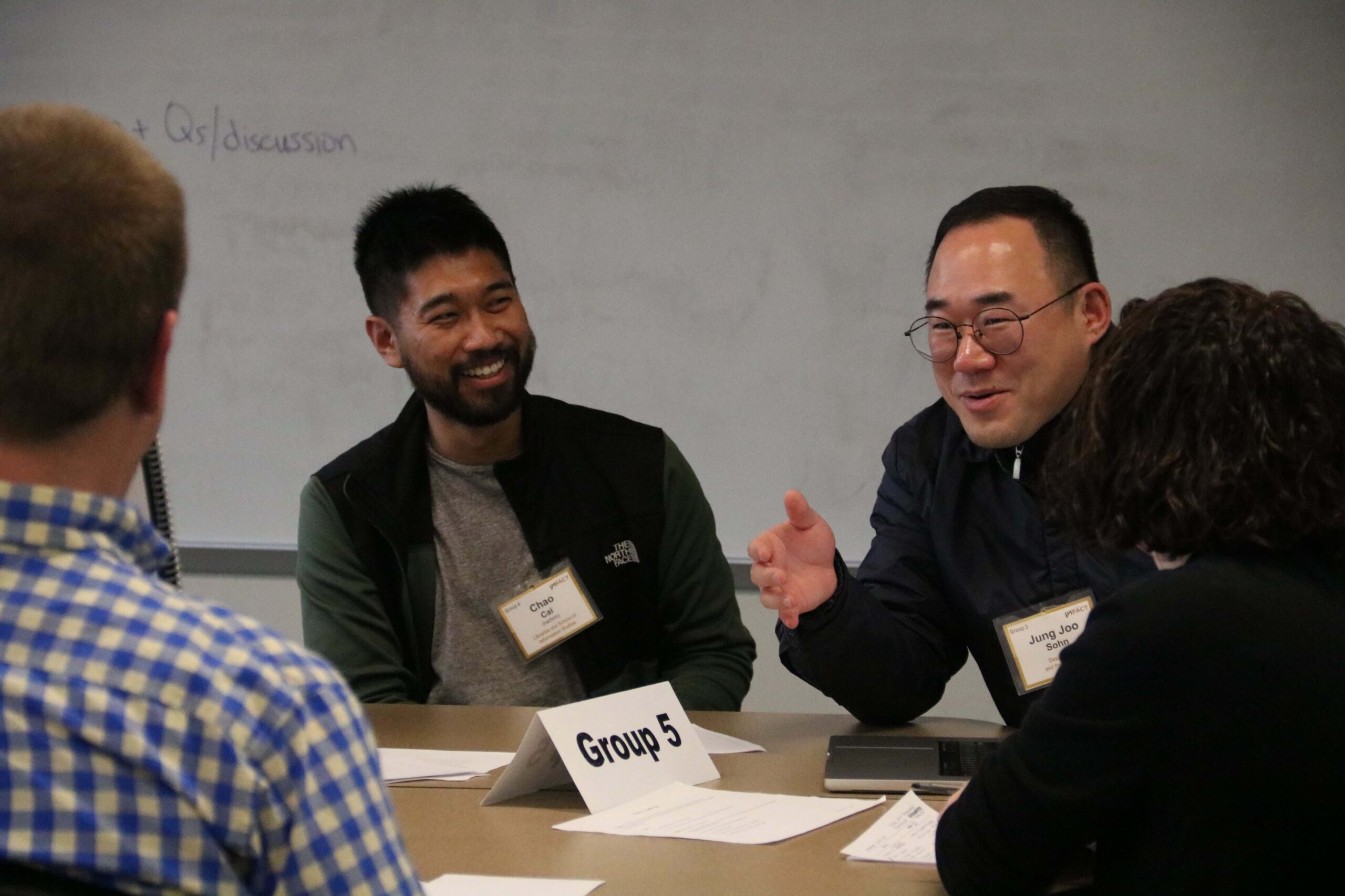 people at a conference table having a conversation.