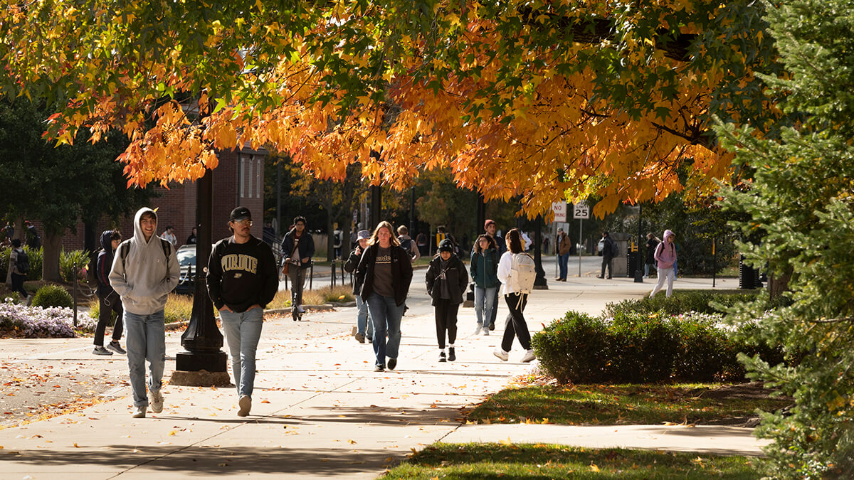 Students walking on the Purdue University campus during the fall season.