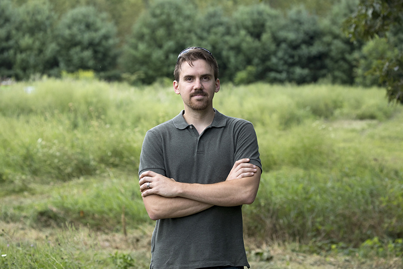 Brady Hardiman in a field by trees.