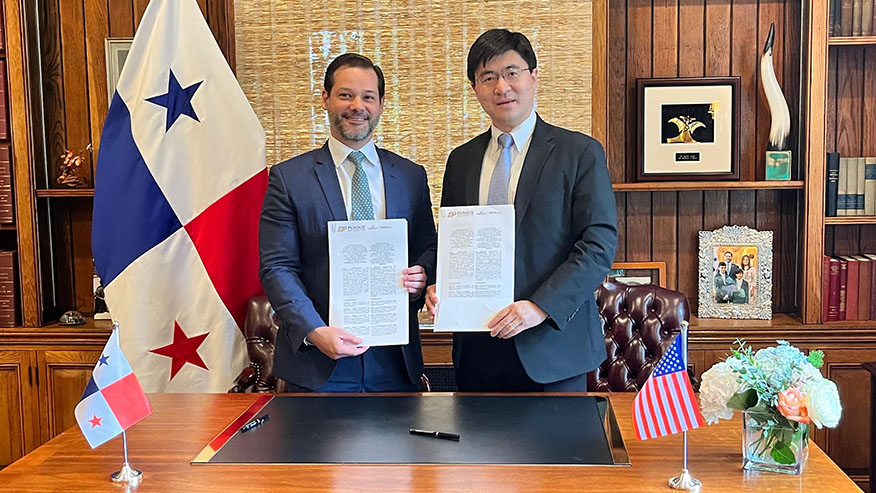 Purdue President Mung Chiang stands with the ambassador of Panama to the U.S. Each holds a document.