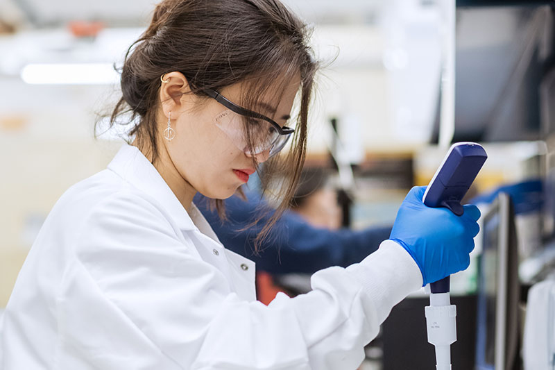 A researcher preparing a sample of vials for characterization in a lyophilization facility