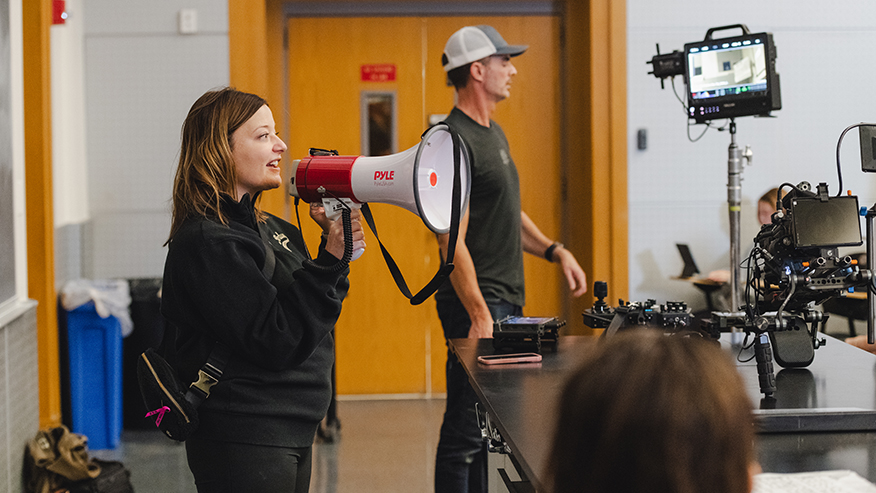 A woman speaks into a megaphone while directing “Boiler to Mars.”