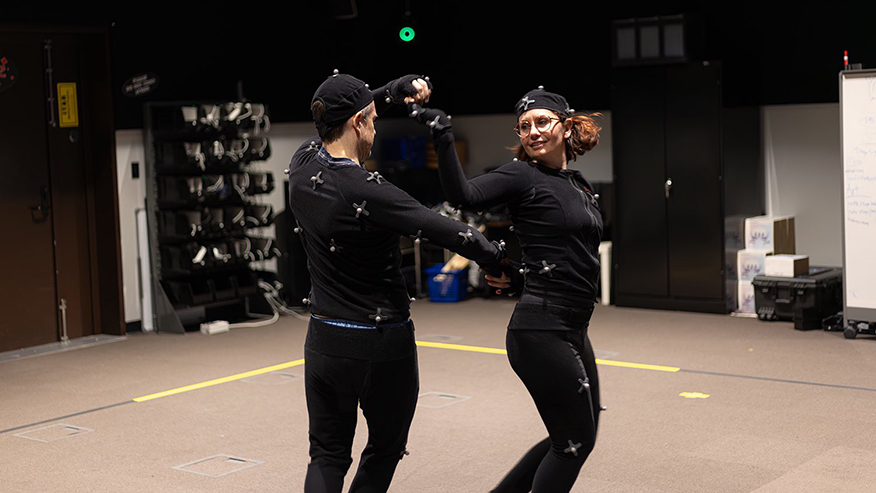 Two researchers in motion capture suits dancing together