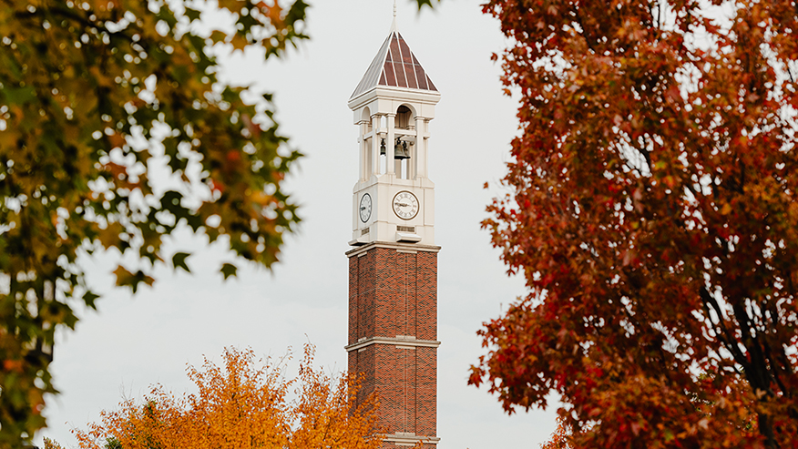 Purdue University bell tower with fall leaves around it