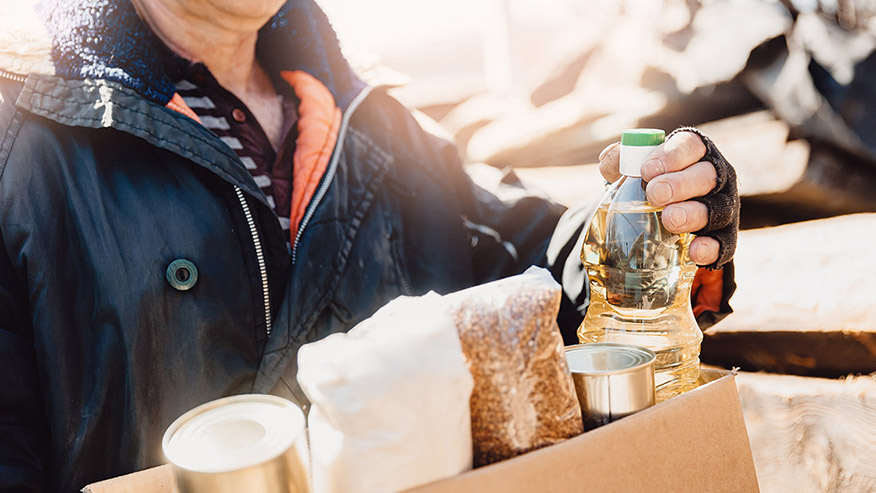 A person holding a box of grocery items