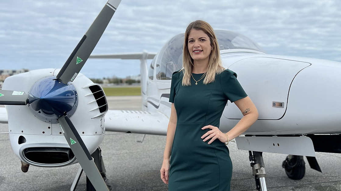 Purdue Global professor Marisa Aguiar next to an airplane.