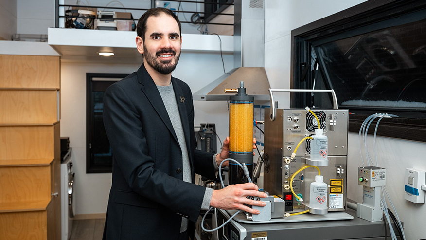 Brandon Boor uses measurement equipment in the kitchen area of a houselike lab