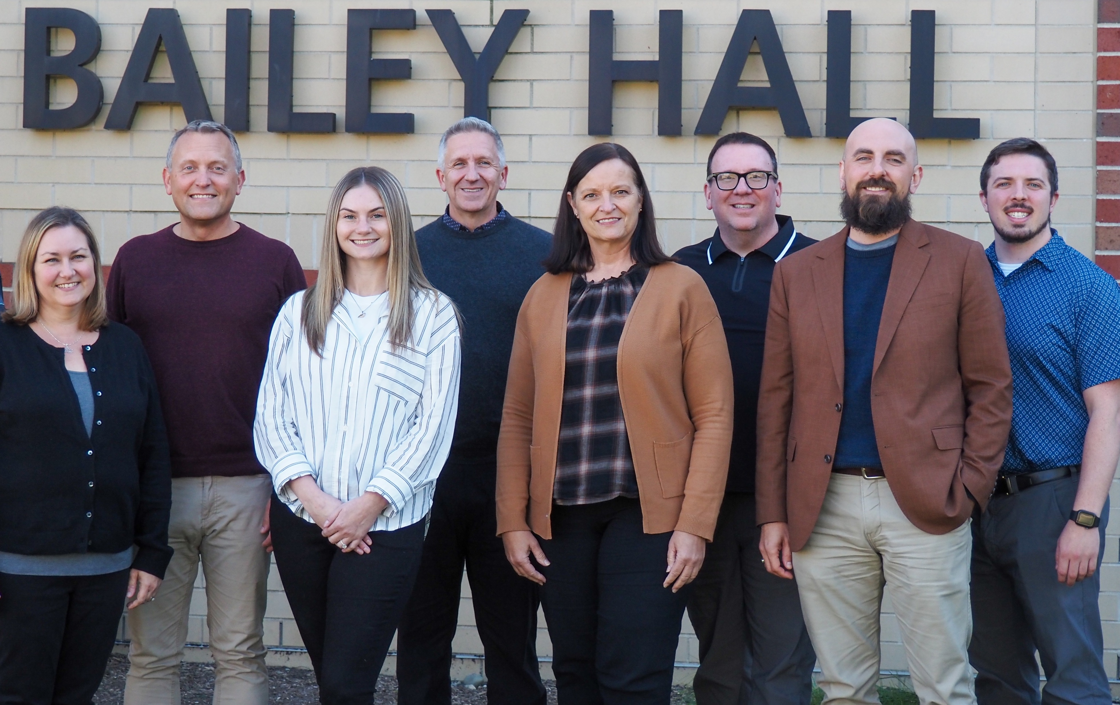 Group photo of all staff members at Purdue Musical Organizations in front of Bailey Hall