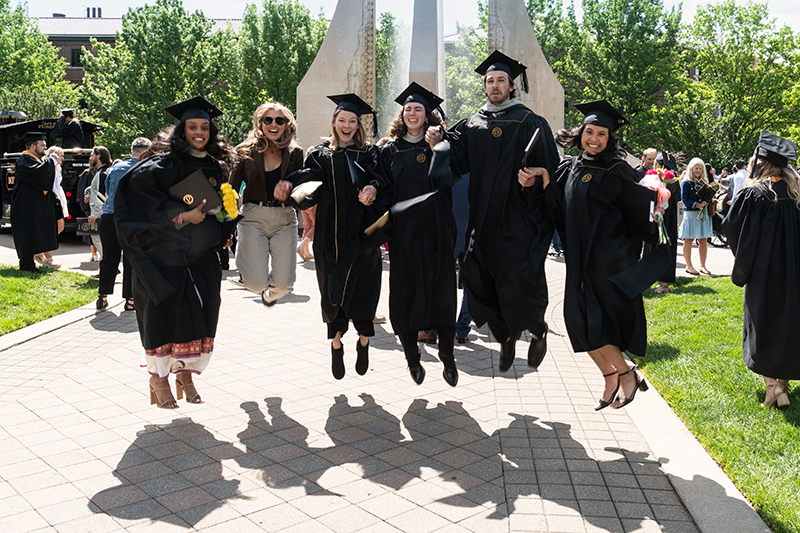 Excited graduates take a celebratory giant leap in front of the fountain on Purdue Mall following Friday’s (May 10) spring commencement ceremony. (Purdue University photo/John Underwood)