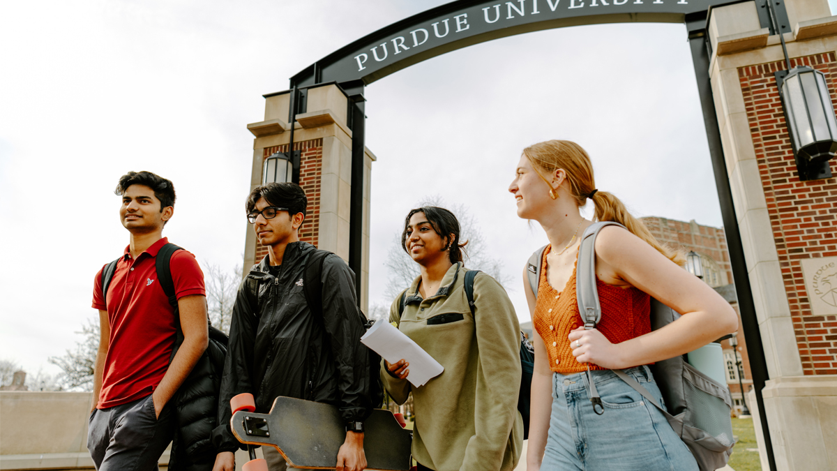 Group of students walking under the Gateway Arch on campus. 