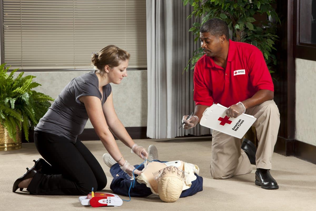 Instructor teaching student how to perform CPR