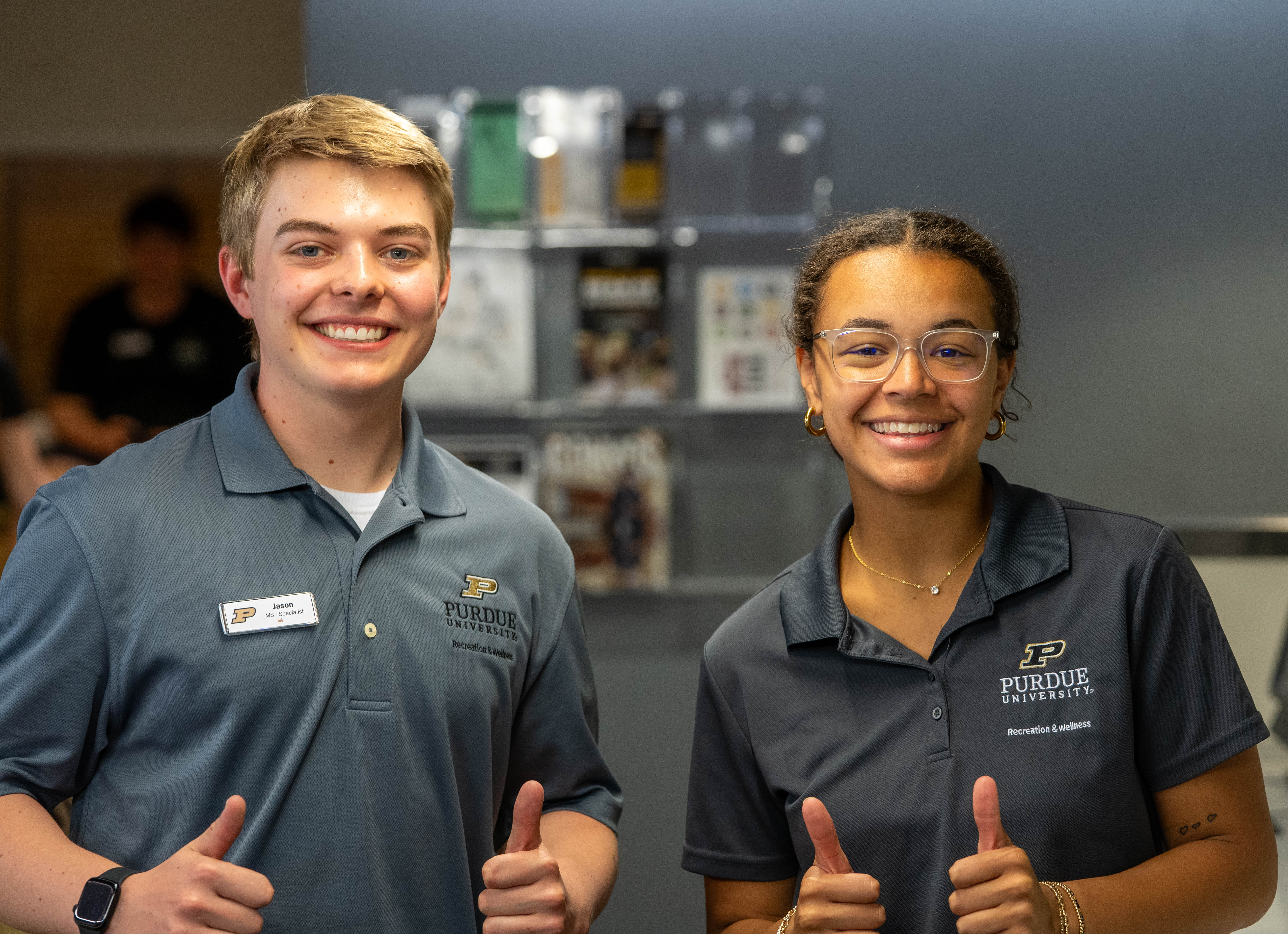 Two smiling staffmembers giving thumbs up