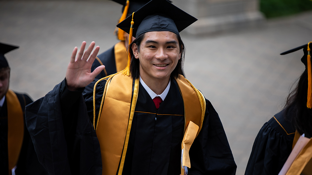 A graduating student in the graduation cap and gown.