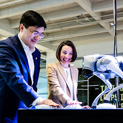 Purdue President Mung Chiang and Lucy Flesch, the Frederick L. Hovde Dean of the College of Science, celebrate with Robodog on Friday (Oct. 18) during dedication ceremonies for the university’s new Hall of Data Science and AI. 