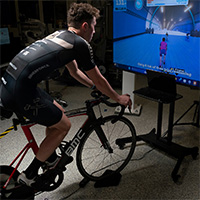 Patrick Cavanaugh, a research engineer at Purdue’s Ray Ewry Sports Engineering Center, demonstrates how virtual cycling competitions function in a remote environment. (Purdue University photo/John Underwood)