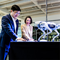 Purdue President Mung Chiang and Lucy Flesch, the Frederick L. Hovde Dean of the College of Science, celebrate with Robodog on Friday (Oct. 18) during dedication ceremonies for the university’s new Hall of Data Science and AI. (Purdue for Life Foundation photo/Gerry Robiños)