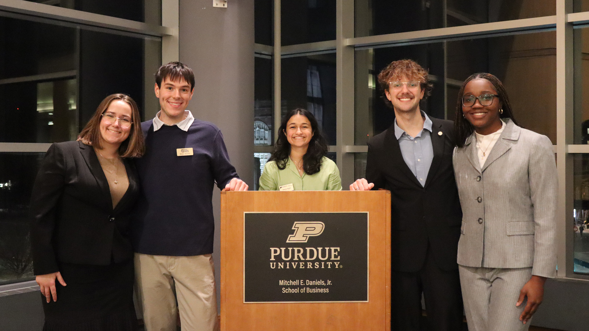 XChange Purdue students standing at a podium at Mitch Daniel's School of Business.