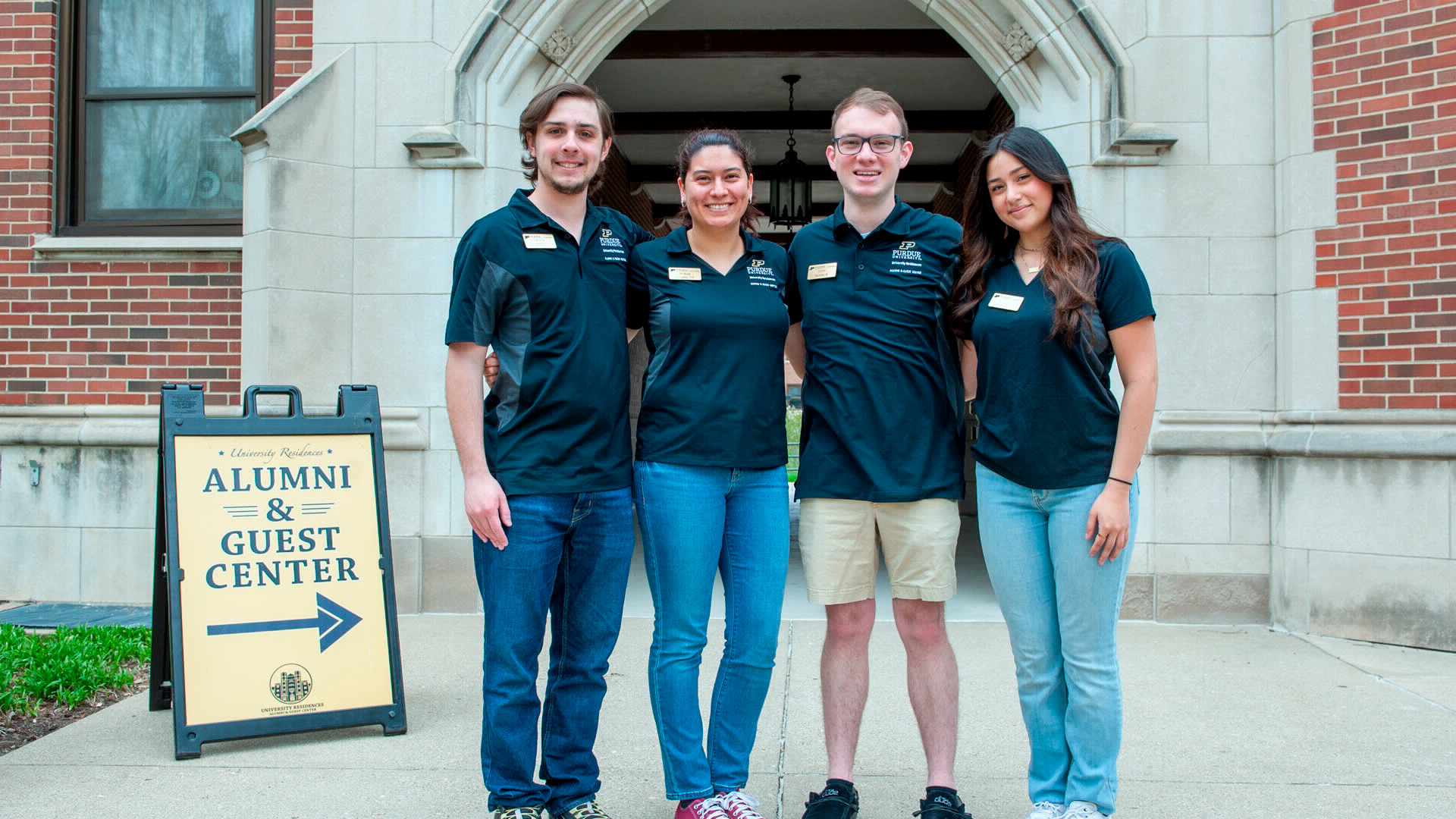 UR Alumni and Guest Center Tour Guides pose for the camera in front of Cary Quad