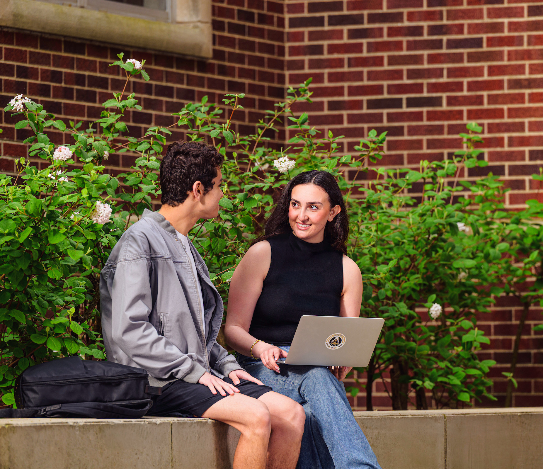 Two Purdue students speaking together outdoors