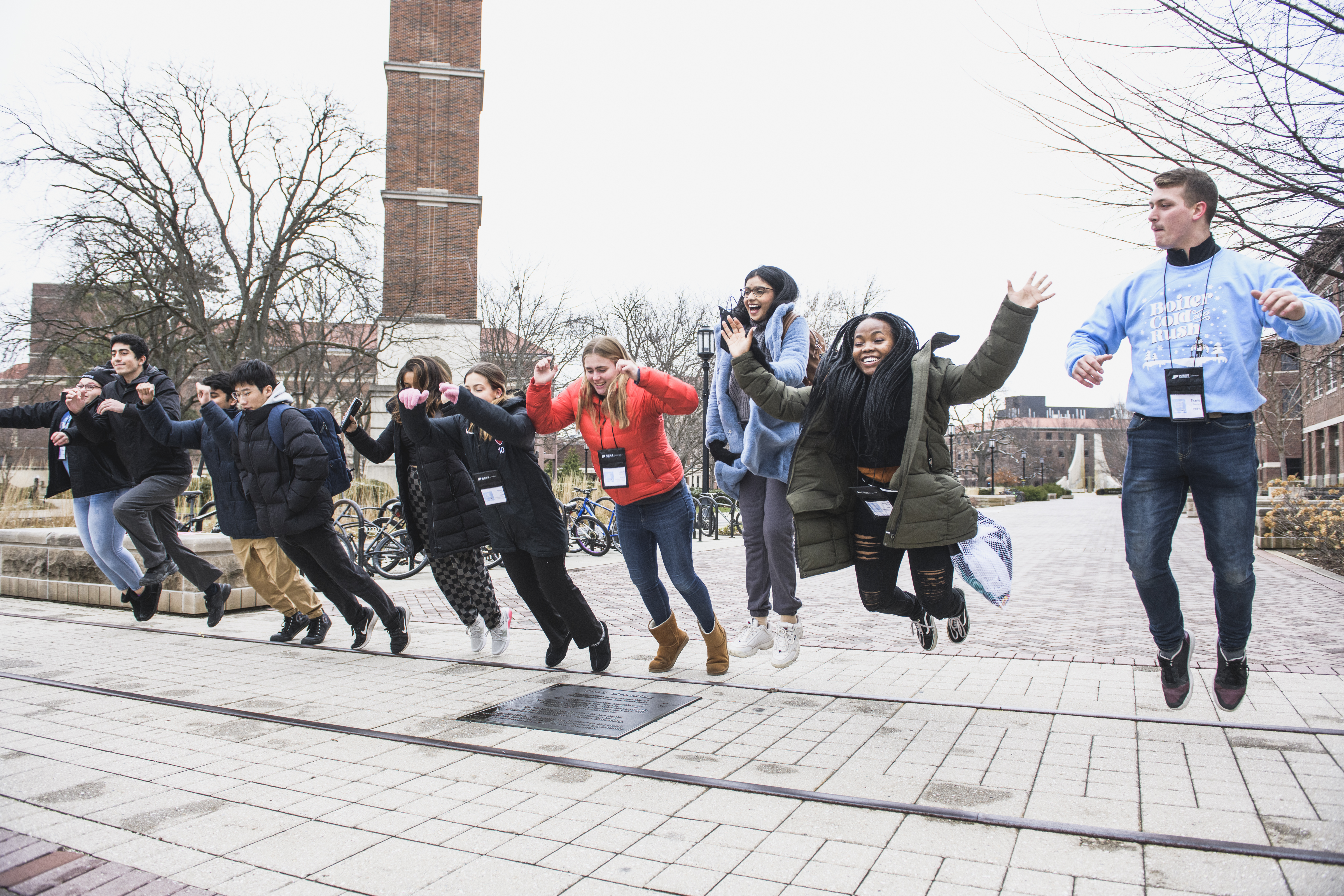 pictured: students jump over the railroad tracks at purdue during a bcr initiation ceremony