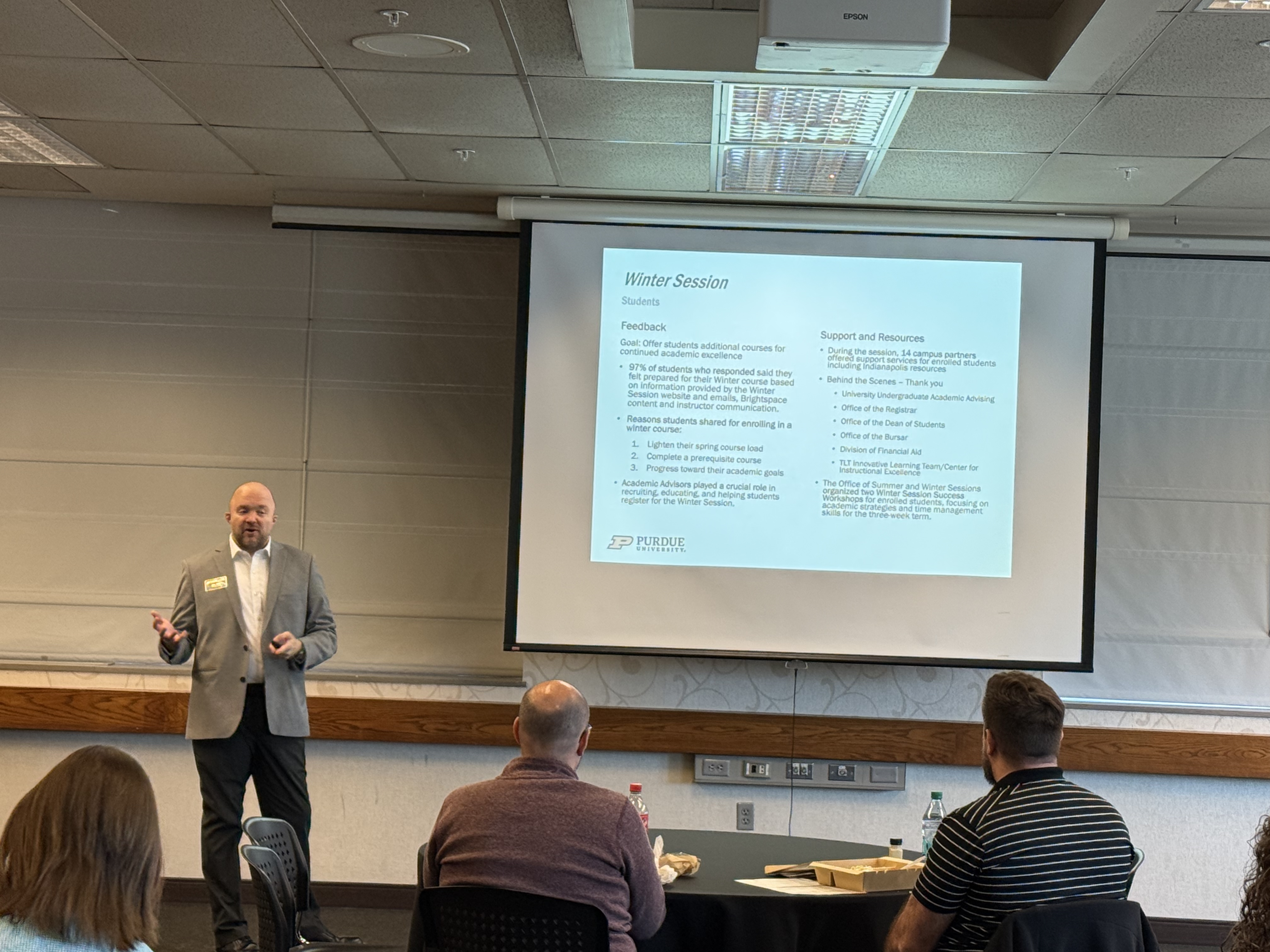 speaker presenting in front of projection screen
