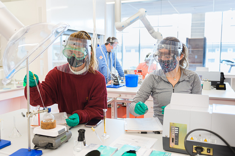 students in lab, masked with face shields