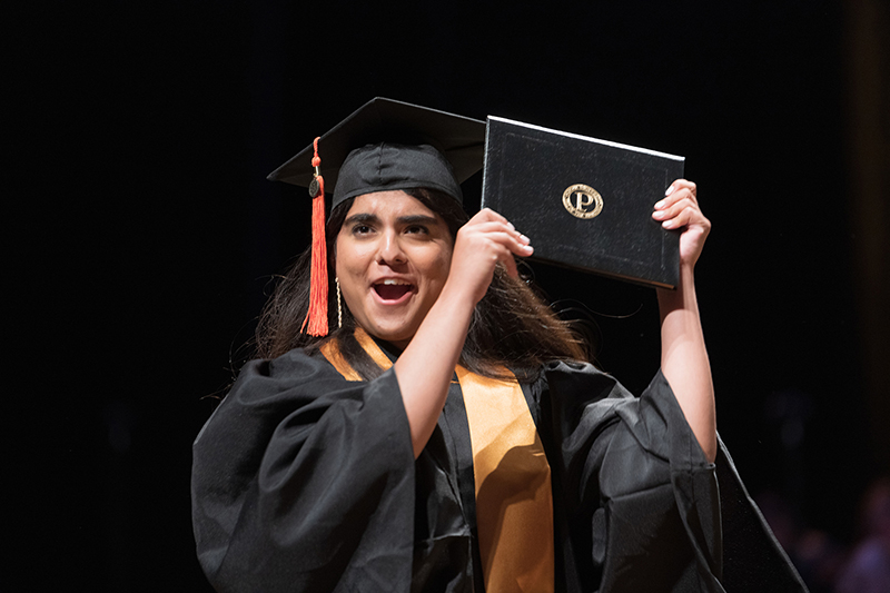 Purdue graduate holding up diploma