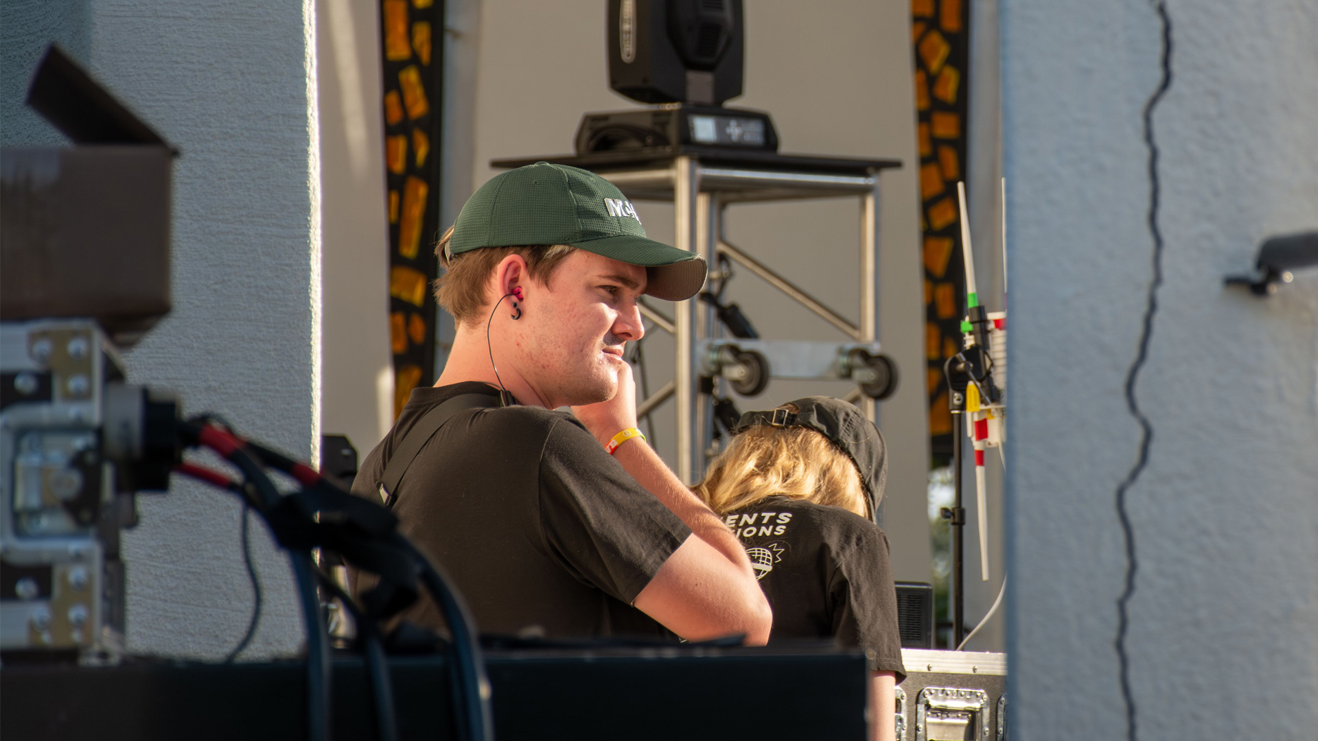 A photo of a student live event staff member putting earplugs in 