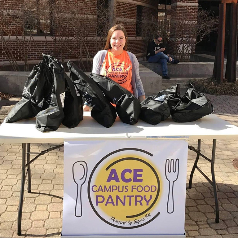 Student volunteer tabling for ACE Campus Food Pantry