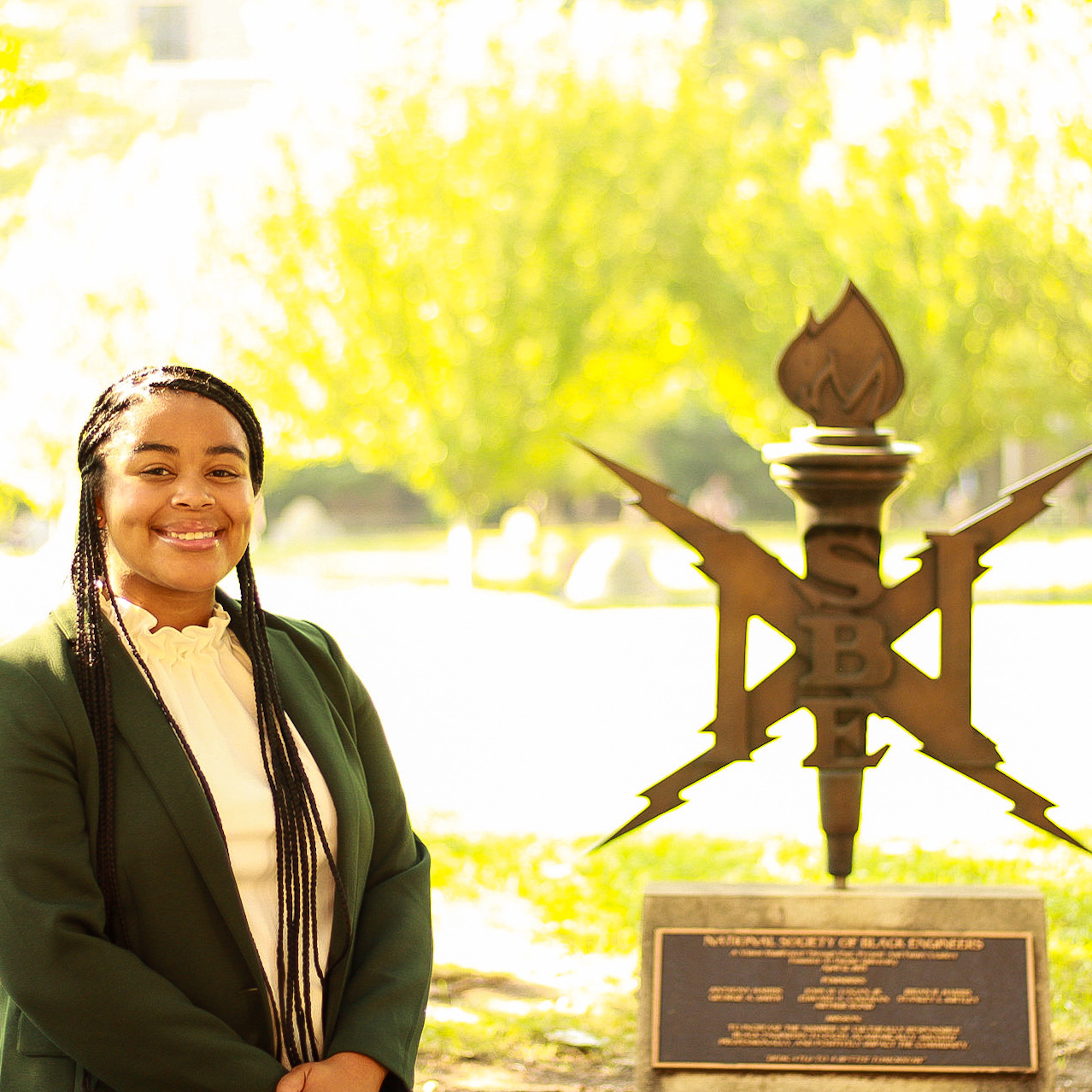 National Society of Black Engineers member standing infront of the NSBE sign