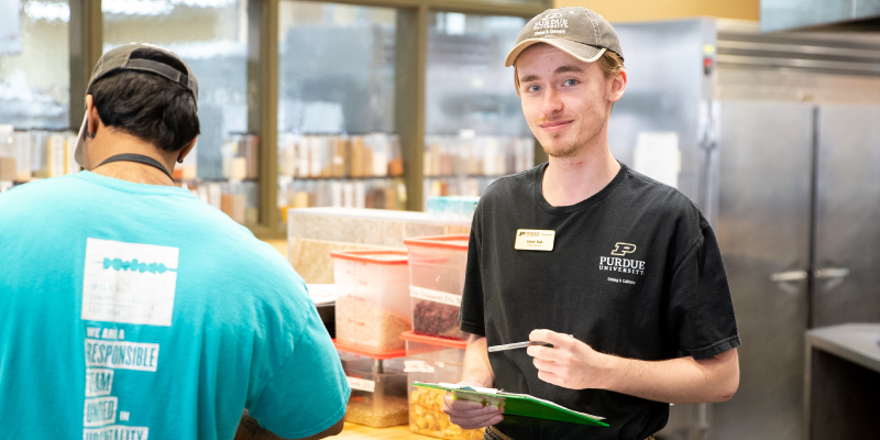 A Purude Dining & Culinary student employee helping a customer