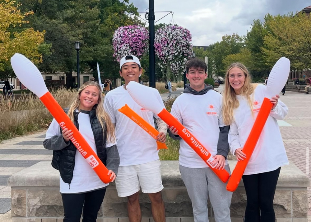 Student pose for a photo with inflatable cotton swabs.
