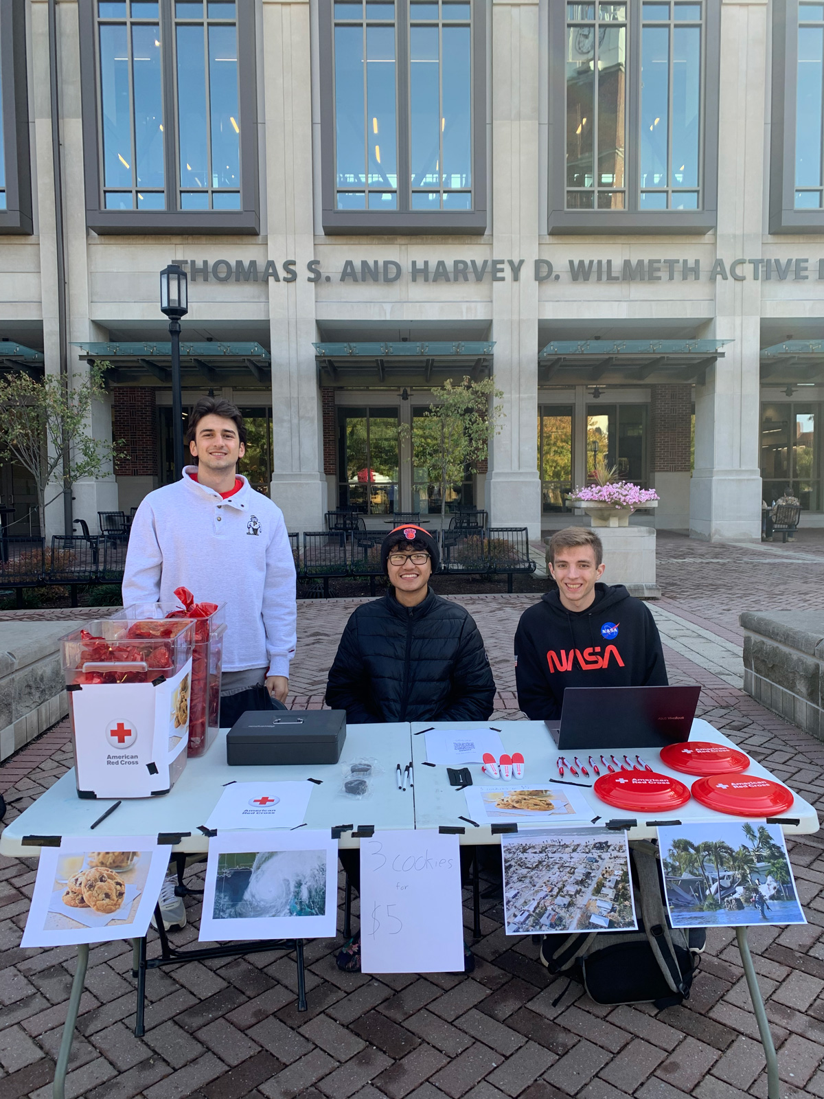 Red Cross club members outside of the WALC selling cookies 